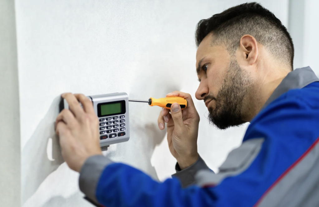 man installing an alarm system